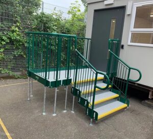 Modular step unit. With green handrails highlighted edges in yellow. Attached to a portacabin